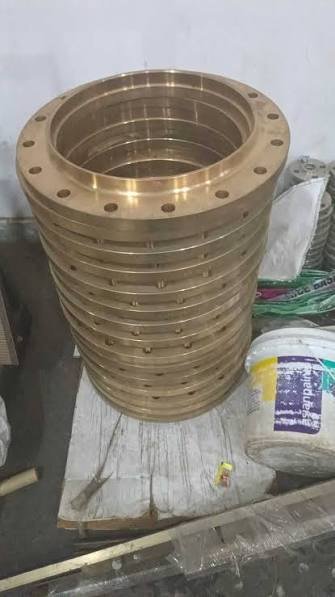 Stack of machined bronze flanges stored upright