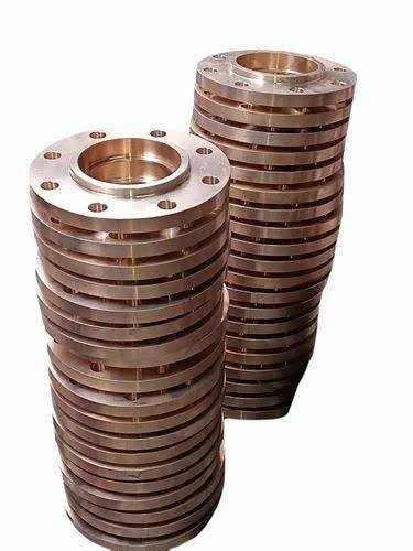 Two upright stacks of finished bronze flanges
