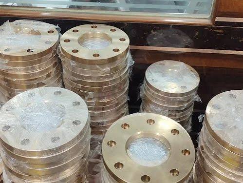 Stock of round bronze flange blanks stacked on a pallet